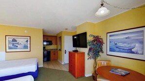 Une chambre d’hôtel équipée d’un lit, d’un bureau, d’une télévision et d’une table à manger.