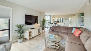 Un salon moderne avec un canapé, une table basse et un meuble pour l’équipement audiovisuel.