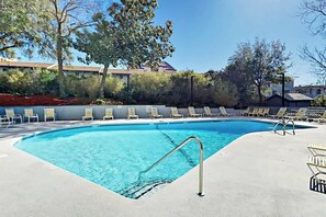 A swimming pool with a metal ladder, surrounded by lounge chairs and trees. - Sea Mark Tower Unit 406 (Myrtle Beach)