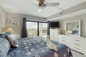 Ein Hotelzimmer mit Bett, Schminktisch, Fernseher und einem Balkon mit Blick.