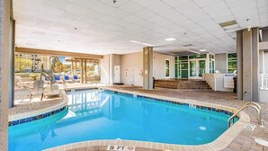 An indoor swimming pool with clear water, a 5 ft depth marking, and a view of the outside through large windows. - Harbourgate Unit 0316 (North Myrtle Beach)