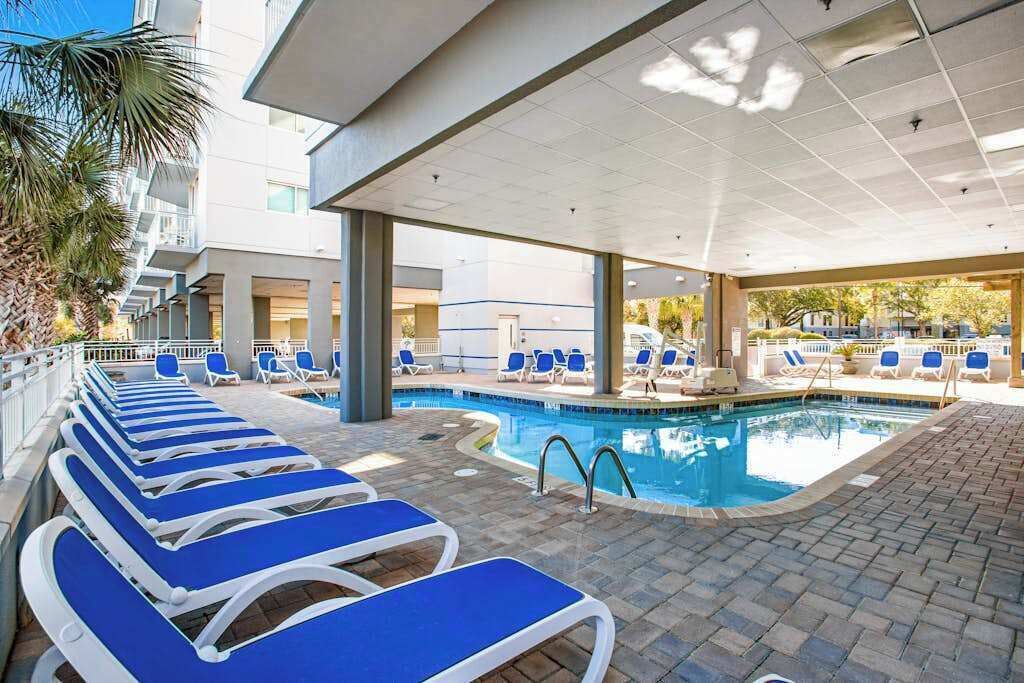 Un espace piscine avec des chaises longues et une piscine.
