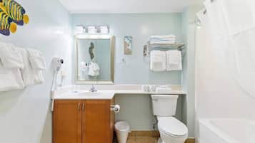 A bathroom with a wooden cabinet, a toilet, a sink, and a bathtub.
