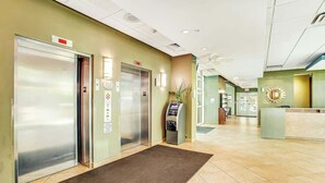 A hotel lobby with two elevators, a reception desk, and a self-service kiosk. - Harbourgate Unit 0320 (North Myrtle Beach)