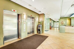 A hotel lobby with two elevators, a reception desk, and a self-service kiosk. - Harbourgate Unit 0320 (North Myrtle Beach)