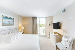 A hotel room with a bed, a TV, a desk, and a balcony. - Harbourgate Unit 0320 (North Myrtle Beach)