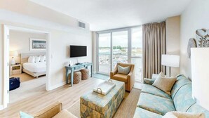 A hotel room with a bed, a desk, a TV, a sofa, and a view of the city. - Harbourgate Unit 0320 (North Myrtle Beach)