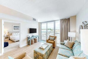 A hotel room with a bed, a desk, a TV, a sofa, and a view of the city. - Harbourgate Unit 0320 (North Myrtle Beach)