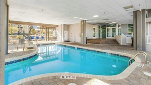 An indoor swimming pool with clear water, a 5 ft depth marking, and a view of the outside through large windows. - Harbourgate Unit 0522 (North Myrtle Beach)
