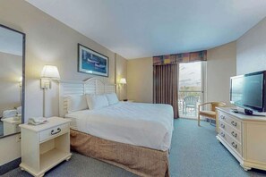 A hotel room with a bed, bedside lamps, a television, a dresser, a mirror, and a window with curtains. - Harbourgate Unit 0522 (North Myrtle Beach)