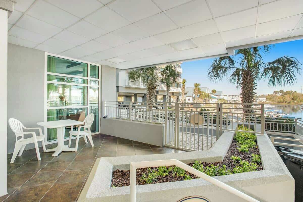A balcony with a dining area, a view of the water, and a railing.