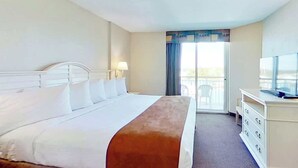 A hotel room with a bed, a television, a dresser, and a view of the outdoors. - Harbourgate Unit 0626 (North Myrtle Beach)