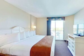 Ein Hotelzimmer mit Bett, Fernseher, Schminktisch und Blick ins Freie.