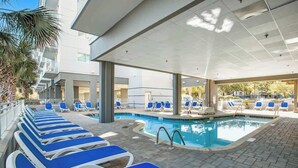 A pool area with lounge chairs and a swimming pool. - Harbourgate Unit 0626 (North Myrtle Beach)