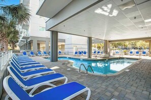 Ein Poolbereich mit Liegestühlen und Schwimmbecken.