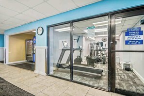 Ein Fitnessstudio mit Laufband, Gewichten und Spiegel.