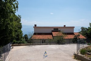 A two-story building with a tiled roof overlooking a body of water. - 4-BR Sea-View Villa with Pool near Opatija (Veprinac)