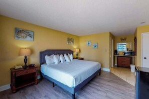 A bedroom with a bed, bedside tables, and artwork on the walls. - Ocean Park Resort 0524 (Myrtle Beach)