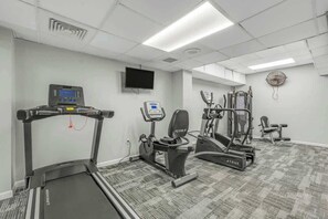A gym with a treadmill, elliptical, and weight machines. - Ocean Park Resort 0722 (Myrtle Beach)