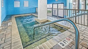 An indoor pool area with clear water, a 3ft depth marker, and a blue wall. - Ocean Park Resort 0722 (Myrtle Beach)