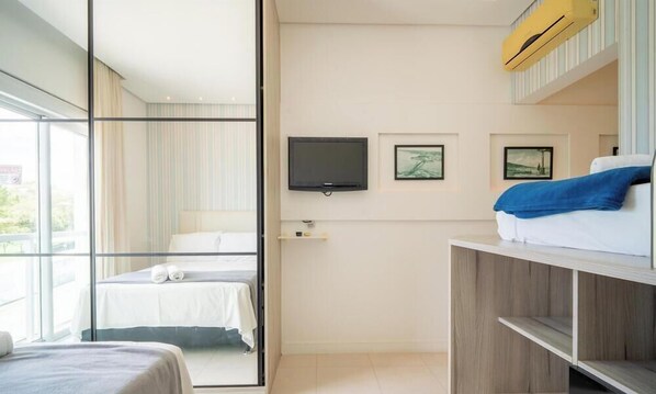 A hotel room with a bed, a television, and a window. - Apartment Sea View in Beachfront Condo Asr0201 (Florianópolis)