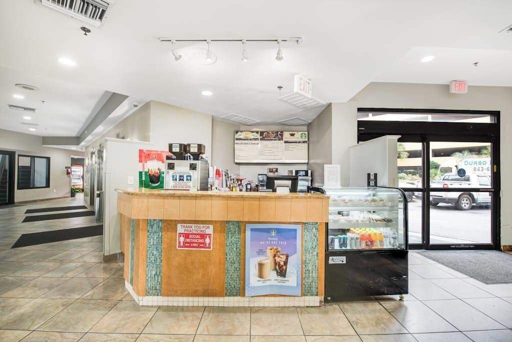 A reception area with a counter, a glass display case, and a door leading outside.
