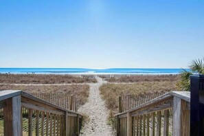 A wooden pathway leading to a beach with a clear view of the ocean. - The Patricia Grand 0304 (Myrtle Beach)