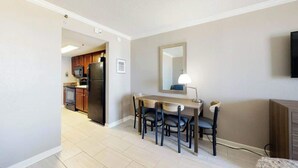 A compact kitchen with a dining area, a flat-screen TV, and a mirror on the wall. - The Patricia Grand 0624 (Myrtle Beach)