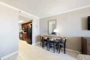 A compact kitchen with a dining area, a flat-screen TV, and a mirror on the wall. - The Patricia Grand 0624 (Myrtle Beach)