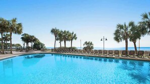 A clear blue swimming pool with lounge chairs and palm trees. - The Patricia Grand 0624 (Myrtle Beach)