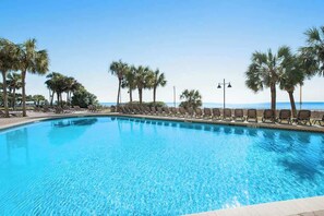 A clear blue swimming pool with lounge chairs and palm trees. - The Patricia Grand 0624 (Myrtle Beach)