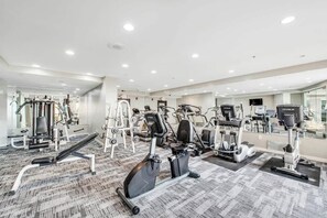 Ein Fitnessstudio mit verschiedenen Trainingsgeräten, darunter Laufbänder, Ergometer und Kraftgeräte.