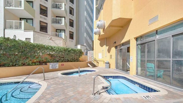 A pool area with two hot tubs and a no lifeguard sign. - The Patricia Grand 0628 (Myrtle Beach)