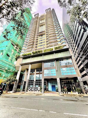 Un edificio de varios pisos con una entrada destacada y señalización.