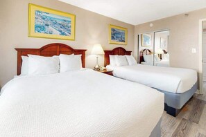 A hotel room with two beds, a nightstand with a lamp, and a mirror. - The Patricia Grand 1002 (Myrtle Beach)
