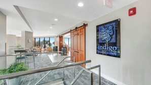 Un interior moderno con una escalera, un comedor y un cartel de Indigo Coastal Kitchen.
