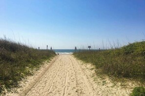 A sandy beach path leading to the ocean with vegetation on either side. - Waipani Unit C-15 Condo (North Myrtle Beach)
