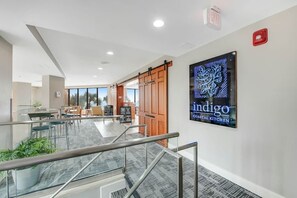 Ein modernes Interieur mit einer Treppe, einem Schild mit der Aufschrift 'indigo coastal kitchen' und Blick auf einen Essbereich.