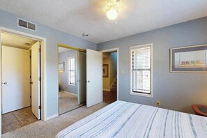 A bedroom with a bed, a door, a window, and a ceiling light. - Dunes Pointe Unit C-14 (Myrtle Beach)