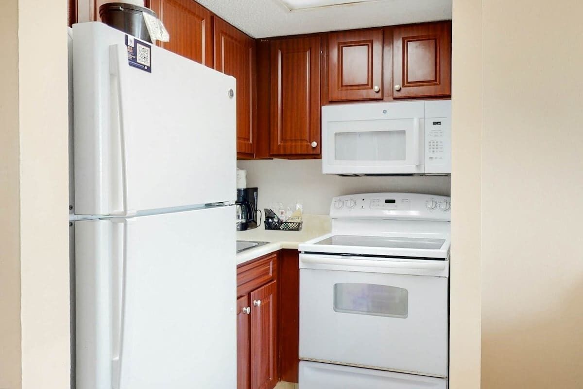 A kitchen with a refrigerator, microwave, and stove.
