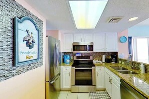 A modern kitchen with white cabinets, stainless steel appliances, and a skylight. - Bay Watch Resort 0811 (North Myrtle Beach)