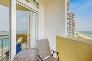 Ein Balkon mit Blick auf den Strand und ein Gebäude.