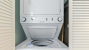 A white front-loading washing machine with a control panel and a door. - Bay Watch Resort 0715 (North Myrtle Beach)