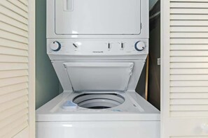 A white front-loading washing machine with a control panel and a door. - Bay Watch Resort 0715 (North Myrtle Beach)