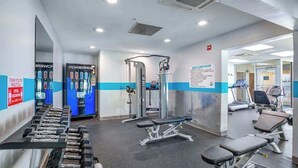 A gym with exercise equipment, benches, and a wall-mounted machine. - Bay Watch Resort 0715 (North Myrtle Beach)