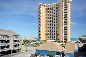 A high-rise hotel with multiple balconies, a parking lot, and a view of the beach. - Shipwatch Pointe I - C303 (Myrtle Beach)