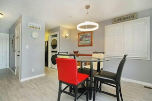 A dining area with a round table, two chairs, a wall clock, and a sign reading 'SUMMERHOUSE'. - Shipwatch Pointe I - C303 (Myrtle Beach)