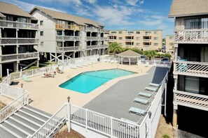 A hotel with multiple balconies, a swimming pool, and a covered seating area. - Shipwatch Pointe I - C303 (Myrtle Beach)