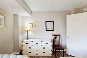 Ein Schlafzimmer mit Bett, Kommode, Stuhl und einer Tür.