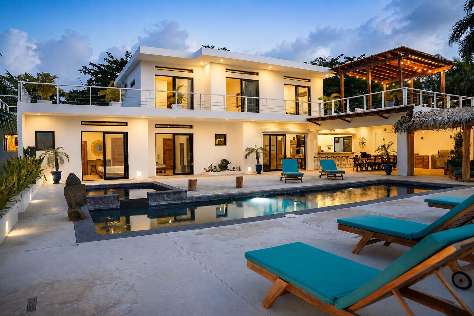 A modern two-story house with a swimming pool, outdoor seating, and a covered patio area.